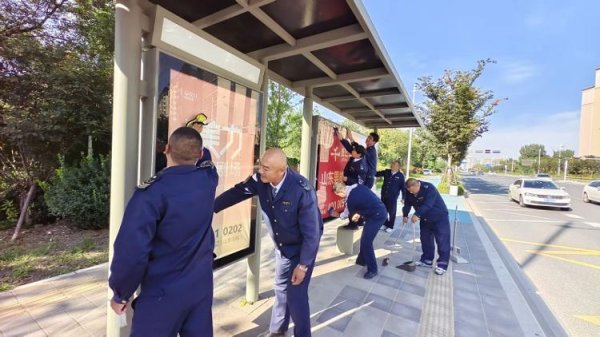 长红配资 清洁公交站牌 城阳巴士驾驶员擦亮城市窗口